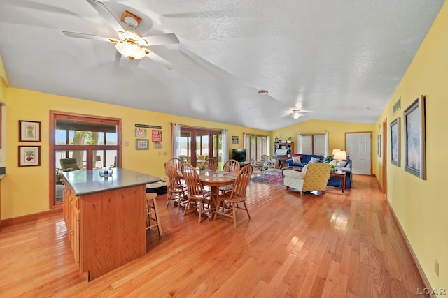 227 Lake View Dr, Hudson, MI 49247 - dining space featuring a ceiling fan, vaulted ceiling, light wood-style floors, a textured ceiling, and baseboards