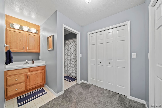 227 Lake View Dr, Hudson, MI 49247 - bathroom featuring a closet, vanity, a textured ceiling, and baseboards