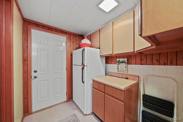 227 Lake View Dr, Hudson, MI 49247 - kitchen featuring freestanding refrigerator, wooden walls, light countertops, and heating unit