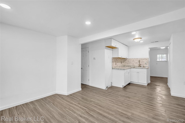 2089 Kenneth St, Burton, MI 48529 - kitchen with a sink, light wood-type flooring, baseboards, white cabinetry, and recessed lighting