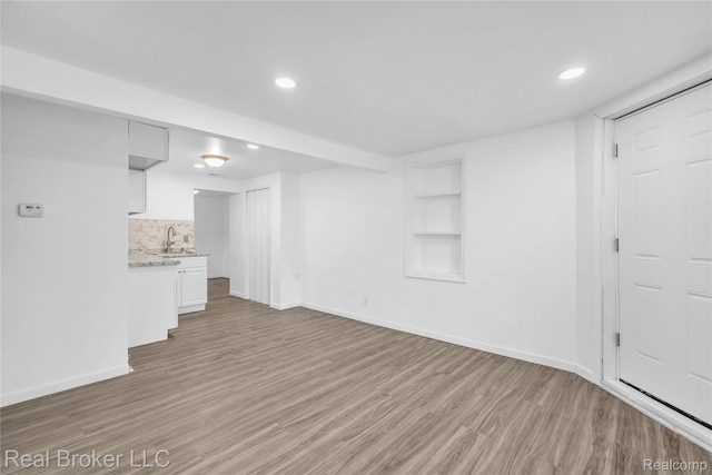 2089 Kenneth St, Burton, MI 48529 - unfurnished living room with a sink, light wood-style floors, baseboards, recessed lighting, and built in features