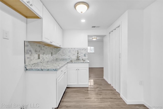2089 Kenneth St, Burton, MI 48529 - kitchen with a sink, light wood-style floors, white cabinetry, and recessed lighting
