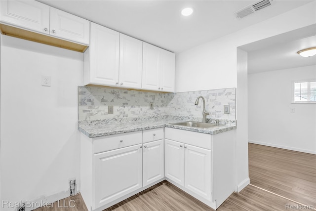 2089 Kenneth St, Burton, MI 48529 - kitchen featuring a sink, decorative backsplash, white cabinetry, light wood finished floors, and recessed lighting