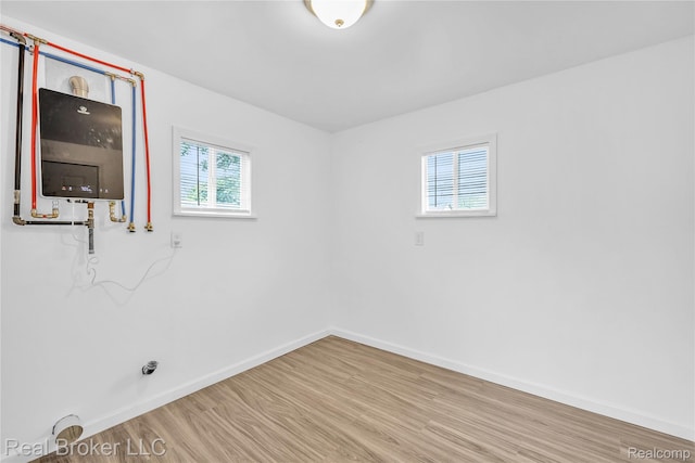 2089 Kenneth St, Burton, MI 48529 - unfurnished room with baseboards, water heater, and wood finished floors