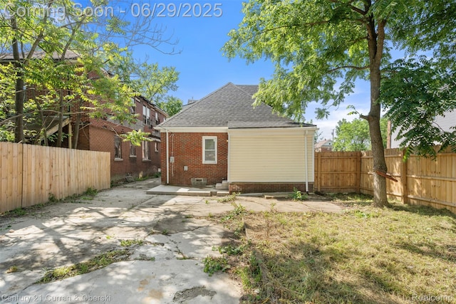4220 Webb St, Detroit, MI 48204 - back of property with roof with shingles, a fenced backyard, brick siding, and a patio area