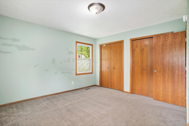 298 Chasseral Ct NW, Comstock Park, MI 49321 - unfurnished bedroom featuring two closets, carpet floors, and baseboards
