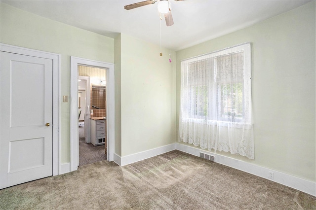 269 E 24th St, Holland, MI 49423 - unfurnished bedroom with carpet flooring, baseboards, connected bathroom, and a ceiling fan