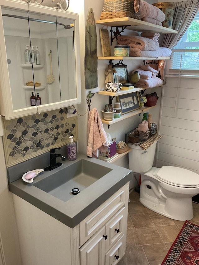 50 N Sprague St, Coldwater, MI 49036 - bathroom featuring toilet, vanity, tile patterned floors, and backsplash