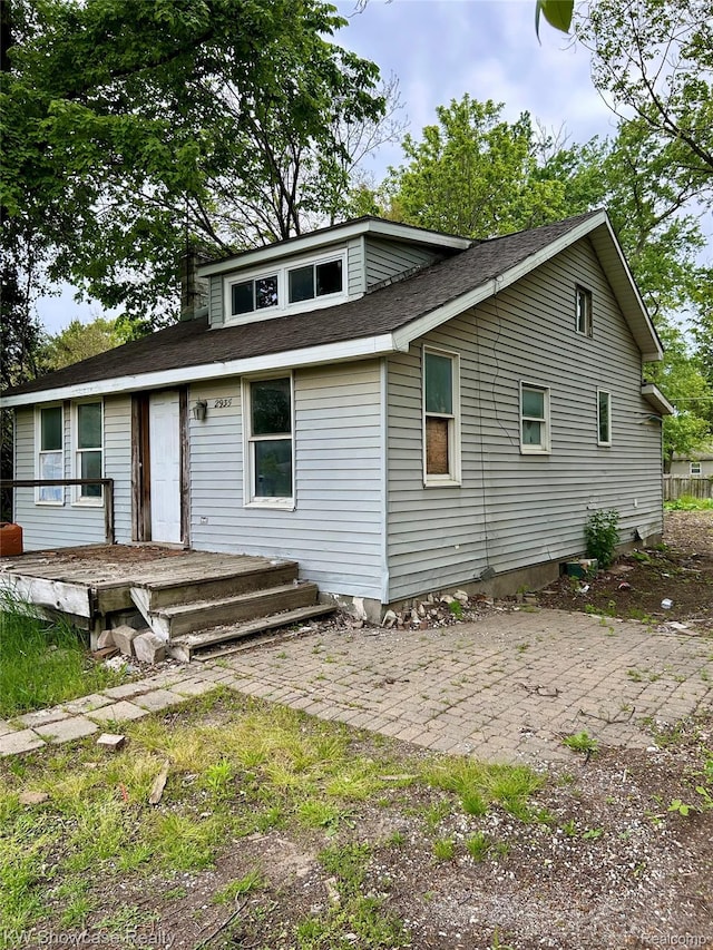 2935 Jackson Blvd, Highland, MI 48356 - view of front of property with a patio area, a deck, and a shingled roof