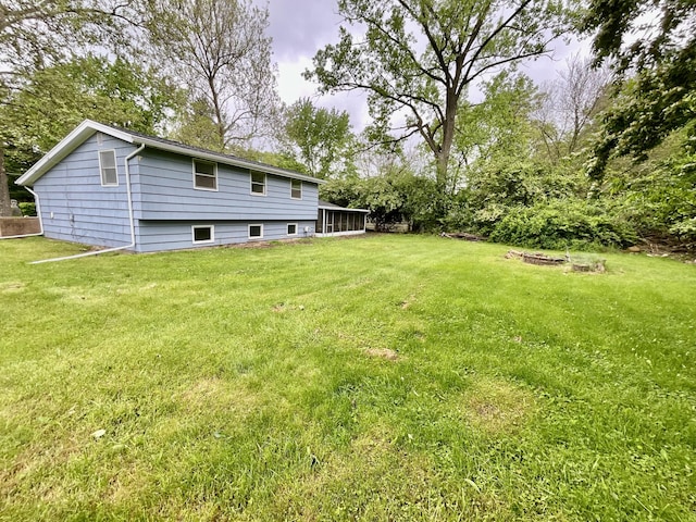 4408 Arbor Dr, Okemos, MI 48864 - view of grassy yard featuring a sunroom and a fire pit