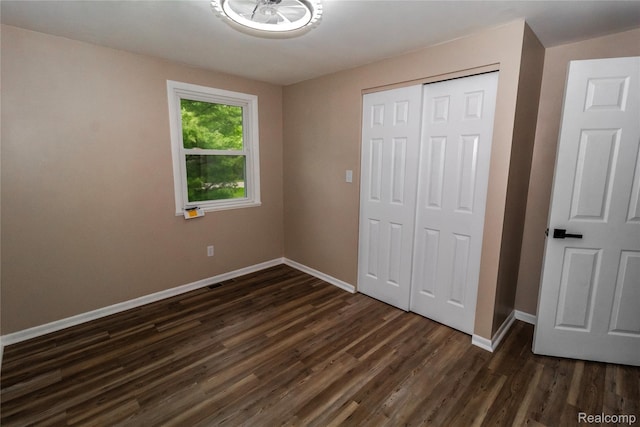519 S Elm St, Lapeer, MI 48446 - unfurnished bedroom with baseboards, dark wood finished floors, and a closet