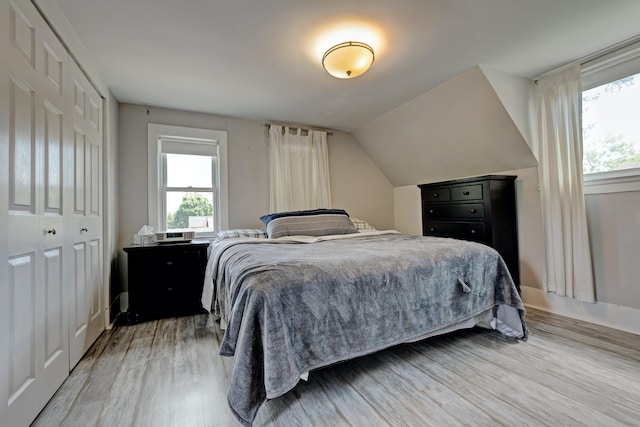 350 N Broadway St, Lake Orion, MI 48362 - bedroom with light wood-style flooring, multiple windows, baseboards, and lofted ceiling