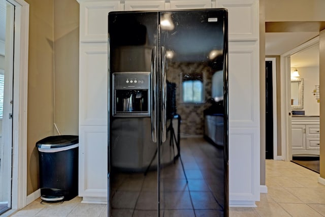 350 N Broadway St, Lake Orion, MI 48362 - kitchen featuring light tile patterned floors, black fridge, white cabinetry, and baseboards