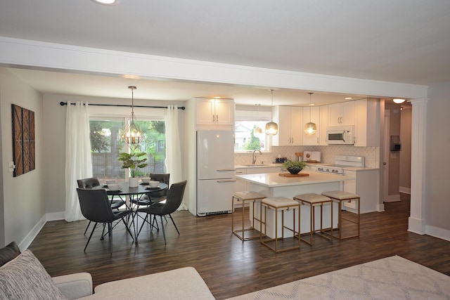 222 S Park St, Zeeland, MI 49464 - kitchen with white appliances, a chandelier, baseboards, and dark wood-style flooring