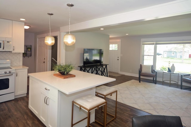 222 S Park St, Zeeland, MI 49464 - kitchen with white appliances, open floor plan, white cabinetry, dark wood-style floors, and decorative backsplash