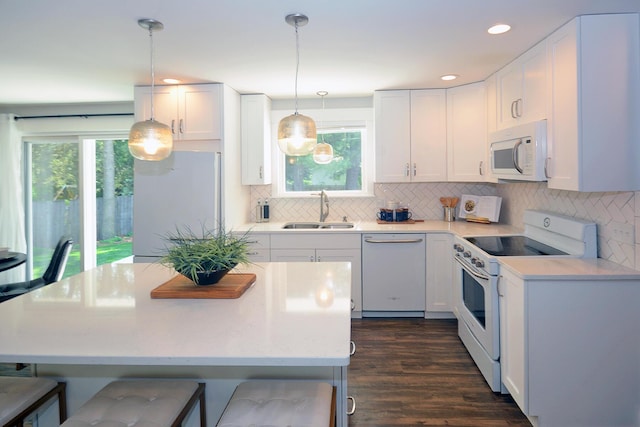 222 S Park St, Zeeland, MI 49464 - kitchen featuring white appliances, a sink, a kitchen breakfast bar, white cabinetry, and recessed lighting