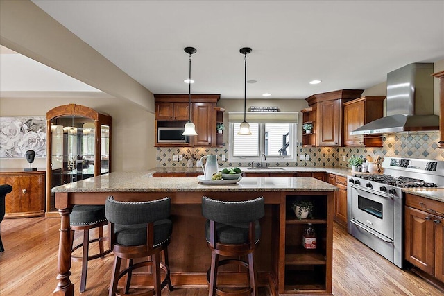 998 Eagle Ave, Ann Arbor, MI 48103 - kitchen with stainless steel range with gas stovetop, open shelves, wall chimney range hood, a sink, and light wood-style floors