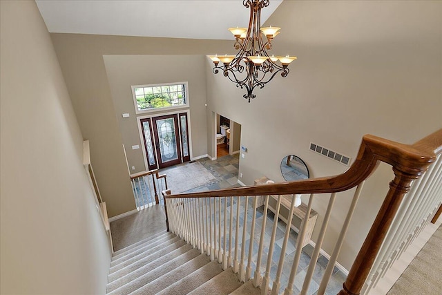 998 Eagle Ave, Ann Arbor, MI 48103 - stairway featuring baseboards, a high ceiling, a chandelier, and carpet flooring