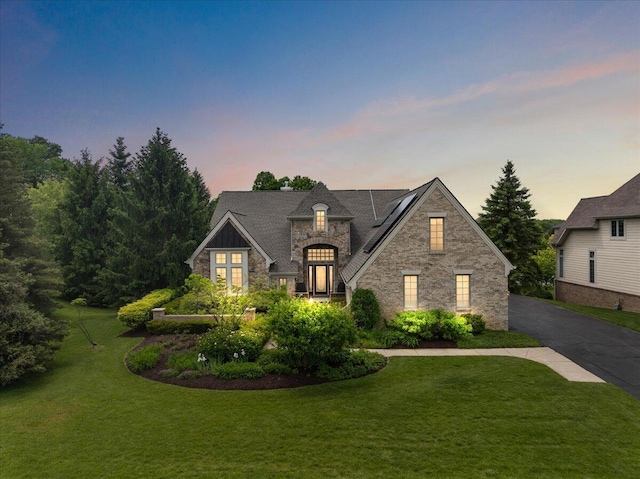998 Eagle Ave, Ann Arbor, MI 48103 - french provincial home with stone siding, solar panels, a yard, and driveway