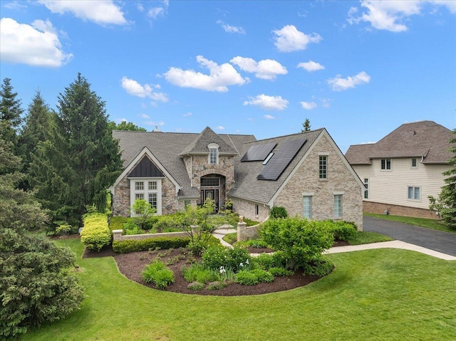 998 Eagle Ave, Ann Arbor, MI 48103 - french provincial home featuring stone siding, solar panels, and a front lawn