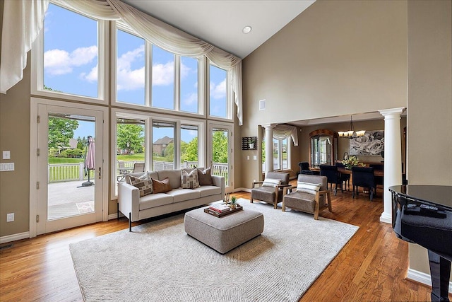 998 Eagle Ave, Ann Arbor, MI 48103 - living room with a chandelier, a high ceiling, ornate columns, healthy amount of natural light, and wood finished floors
