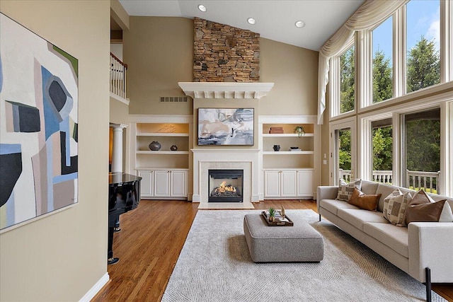 998 Eagle Ave, Ann Arbor, MI 48103 - living area featuring high vaulted ceiling, a large fireplace, wood finished floors, built in features, and recessed lighting