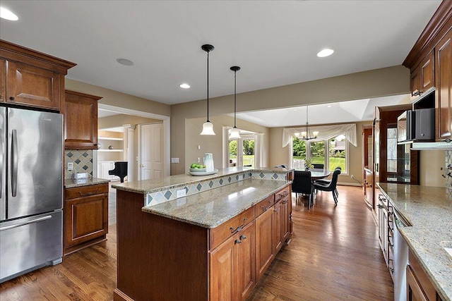 998 Eagle Ave, Ann Arbor, MI 48103 - kitchen with freestanding refrigerator, dark wood finished floors, light stone counters, a chandelier, and decorative backsplash