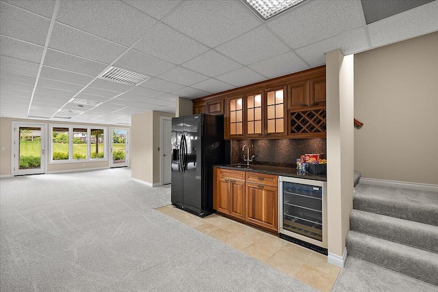 998 Eagle Ave, Ann Arbor, MI 48103 - indoor wet bar featuring beverage cooler, black fridge with ice dispenser, light carpet, baseboards, and a drop ceiling