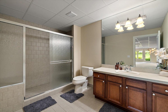 998 Eagle Ave, Ann Arbor, MI 48103 - bathroom featuring tile patterned flooring, toilet, vanity, a shower stall, and a paneled ceiling