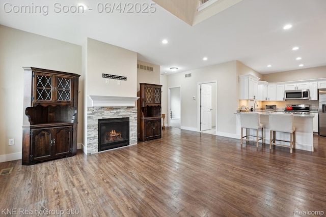 1720 Carlisle St, Howell, MI 48855 - living room featuring wood finished floors, baseboards, recessed lighting, and a fireplace