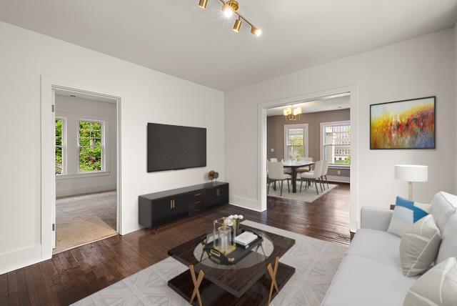 1174 Taylor St, Detroit, MI 48202 - living room featuring a chandelier, healthy amount of natural light, wood finished floors, and baseboards