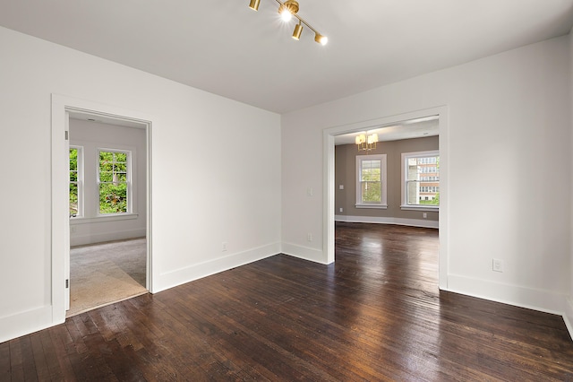 1174 Taylor St, Detroit, MI 48202 - empty room featuring a chandelier, dark wood-style flooring, and baseboards