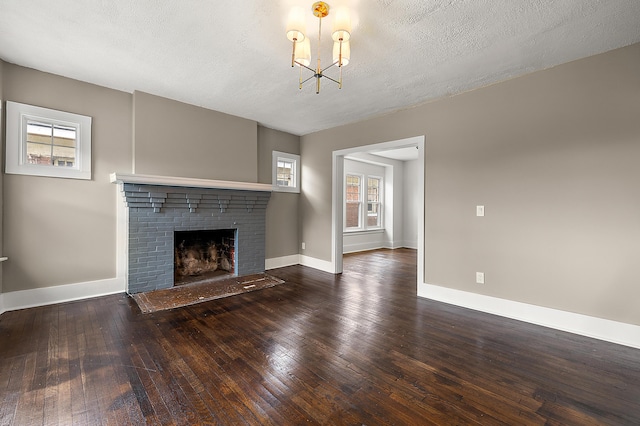 1174 Taylor St, Detroit, MI 48202 - unfurnished living room featuring hardwood / wood-style floors, a brick fireplace, baseboards, a chandelier, and a textured ceiling