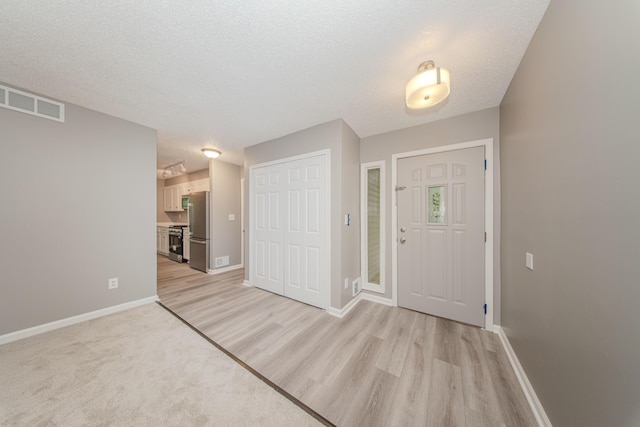 242 S Wallace Blvd, Ypsilanti, MI 48197 - foyer with light wood-style floors, baseboards, and a textured ceiling