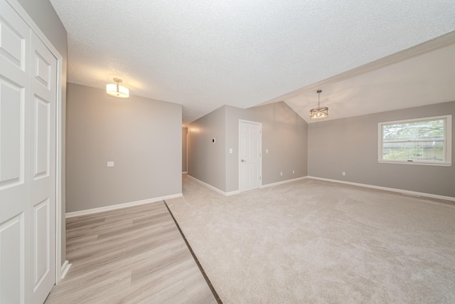 242 S Wallace Blvd, Ypsilanti, MI 48197 - unfurnished room featuring baseboards, a textured ceiling, lofted ceiling, and light wood finished floors