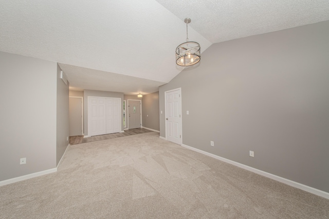 242 S Wallace Blvd, Ypsilanti, MI 48197 - unfurnished bedroom with light colored carpet, baseboards, a chandelier, lofted ceiling, and a textured ceiling