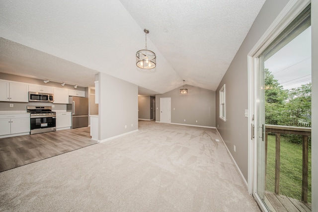242 S Wallace Blvd, Ypsilanti, MI 48197 - unfurnished living room featuring light colored carpet, a textured ceiling, baseboards, a chandelier, and vaulted ceiling