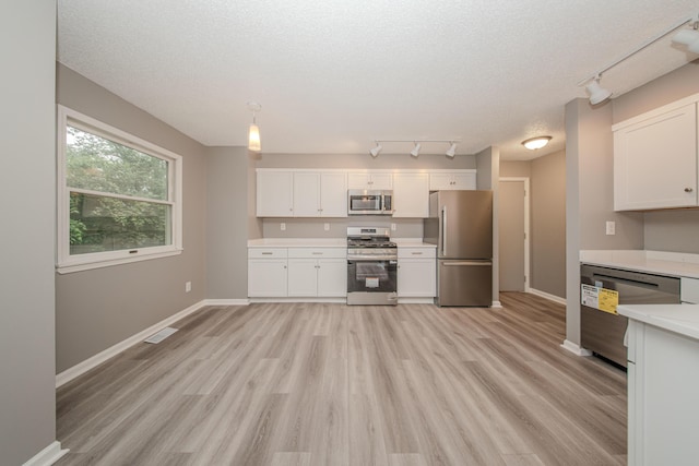 242 S Wallace Blvd, Ypsilanti, MI 48197 - kitchen with stainless steel appliances, track lighting, baseboards, light countertops, and white cabinetry