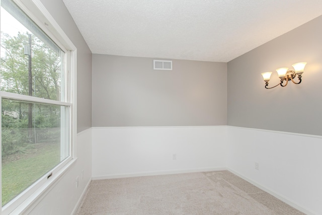 242 S Wallace Blvd, Ypsilanti, MI 48197 - unfurnished room with carpet floors, baseboards, a textured ceiling, and a chandelier