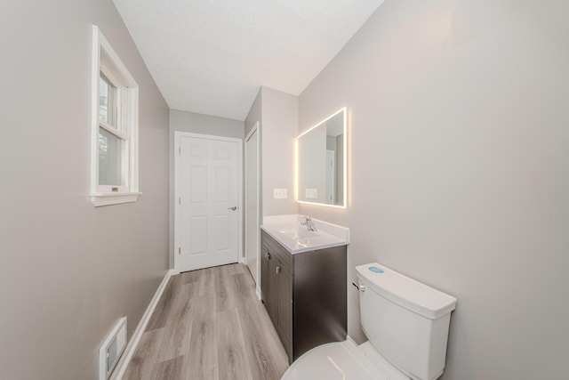 242 S Wallace Blvd, Ypsilanti, MI 48197 - bathroom featuring vanity, toilet, wood finished floors, a textured ceiling, and baseboards
