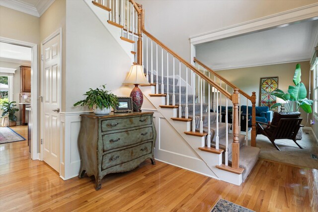 71438 Forest Eagle Ln, Niles, MI 49120 - stairway with crown molding, wood finished floors, and a wainscoted wall
