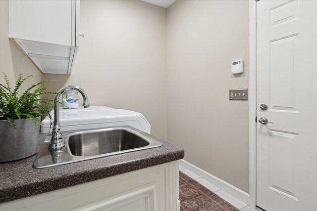 71438 Forest Eagle Ln, Niles, MI 49120 - laundry room with cabinet space, dark tile patterned floors, and baseboards