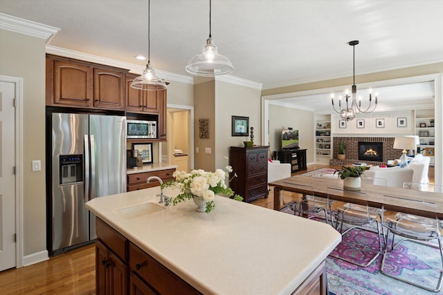 71438 Forest Eagle Ln, Niles, MI 49120 - kitchen with appliances with stainless steel finishes, a sink, light countertops, light wood-style floors, and crown molding