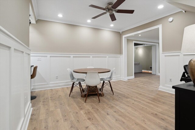 71438 Forest Eagle Ln, Niles, MI 49120 - dining room featuring a decorative wall, ceiling fan, crown molding, wainscoting, and light wood-type flooring