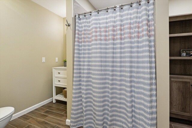 71438 Forest Eagle Ln, Niles, MI 49120 - bathroom with toilet, wood finish floors, baseboards, and a shower with shower curtain