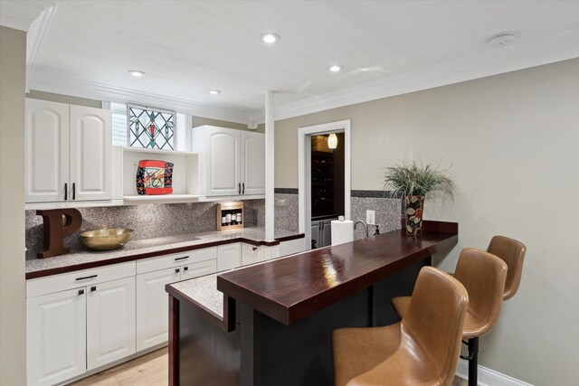 71438 Forest Eagle Ln, Niles, MI 49120 - kitchen with crown molding, open shelves, decorative backsplash, white cabinets, and a kitchen bar