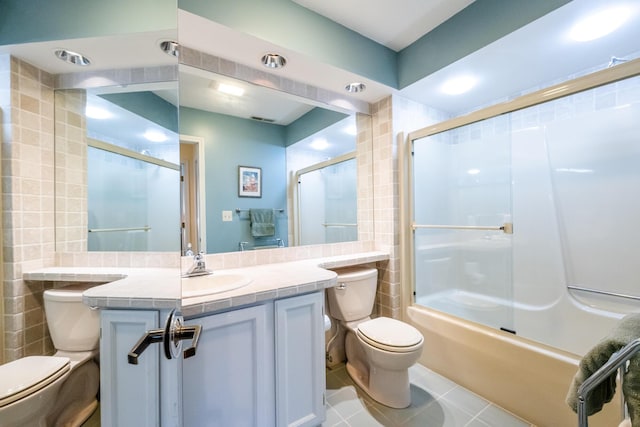 193 Wayne St, Saint Joseph, MI 49085 - bathroom with toilet, tile walls, tile patterned flooring, vanity, and shower / bath combination with glass door