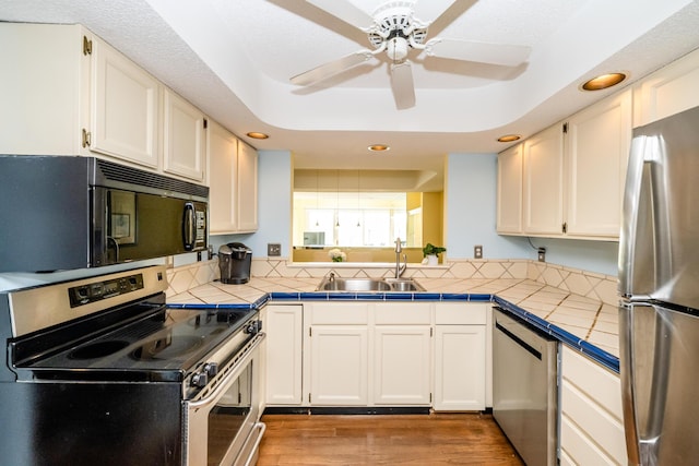 193 Wayne St, Saint Joseph, MI 49085 - kitchen with stainless steel appliances, tile countertops, recessed lighting, a sink, and a ceiling fan