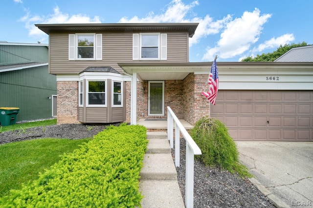 5662 Caren Dr, Ypsilanti, MI 48197 - traditional-style house with brick siding, driveway, and a garage