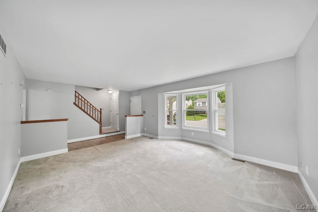 5662 Caren Dr, Ypsilanti, MI 48197 - unfurnished living room with carpet, stairs, and baseboards